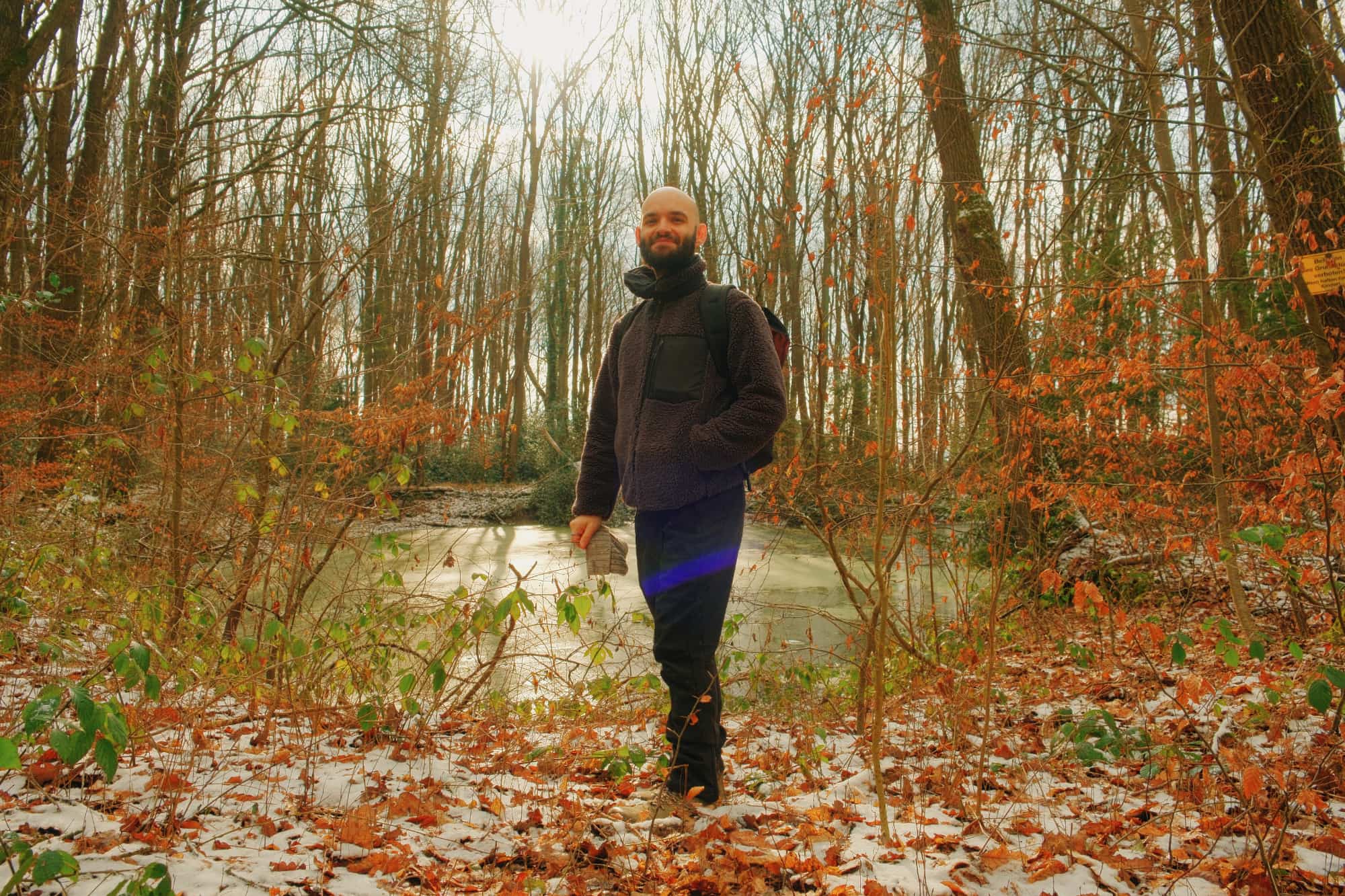 Selbstbewusster Glatzenträger beim Achtsamkeits-Spaziergang im Herbstwald, Digital Detox und Naturverbundenheit als Weg zur Authentizität