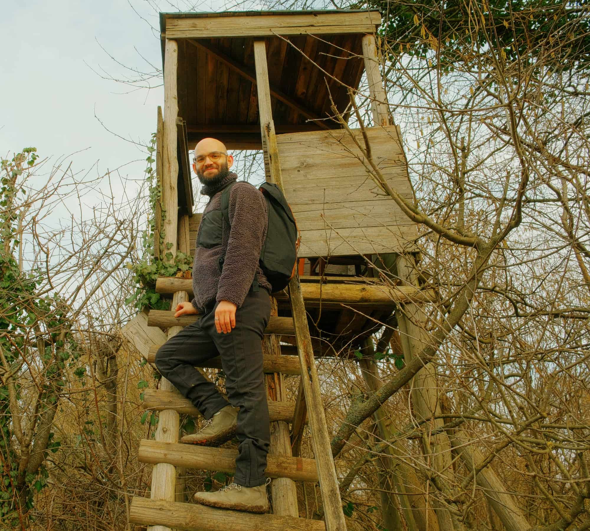 Authentischer Glatzenträger auf Hochsitz im Winterwald, Digital Detox und Naturverbundenheit als Weg zu mehr Selbstbewusstsein