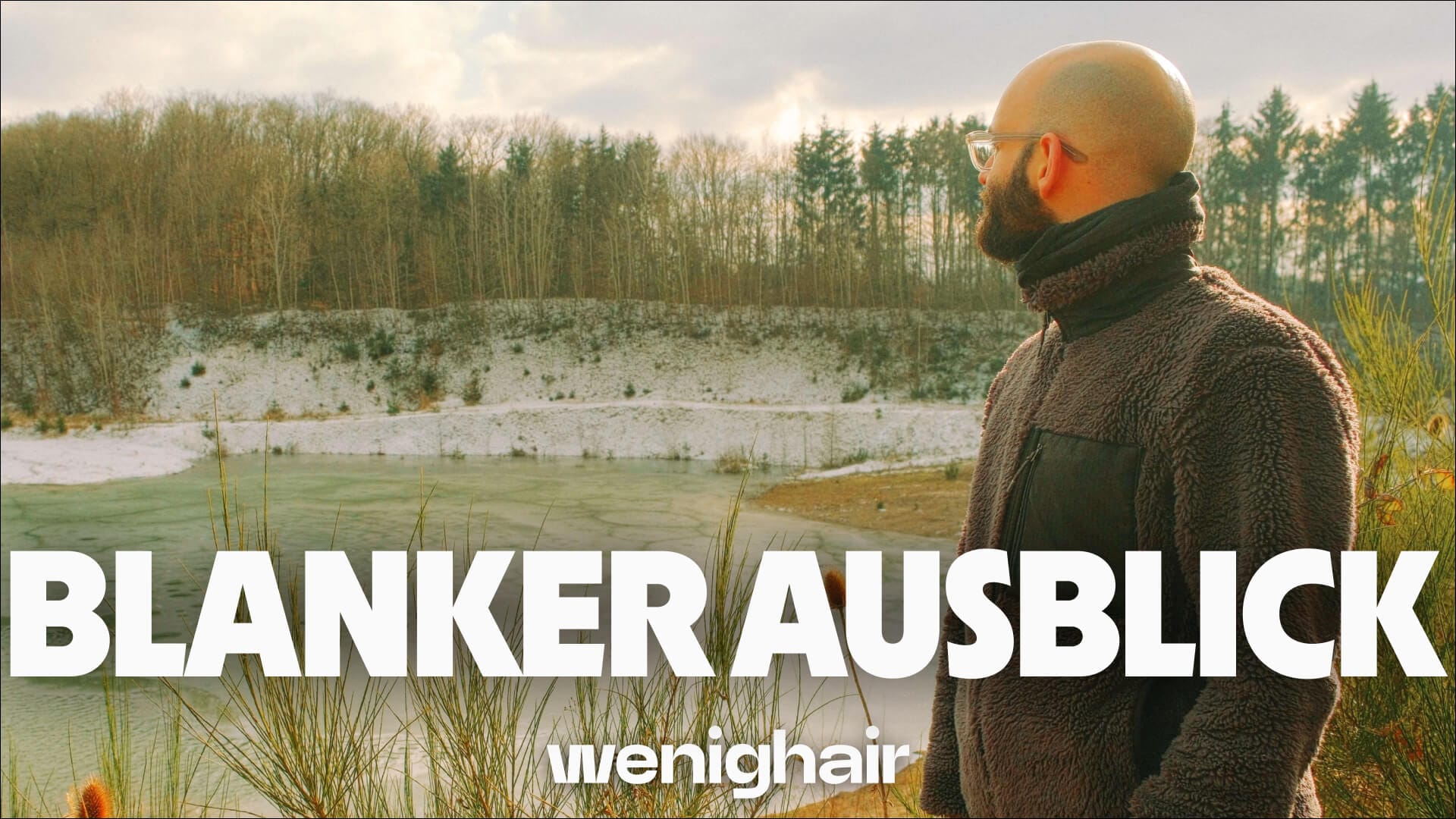 Aussicht auf türkisfarbenen See im Winterlicht, umgeben von schneebedeckten Hängen, Text “BLANKER AUSBLICK”